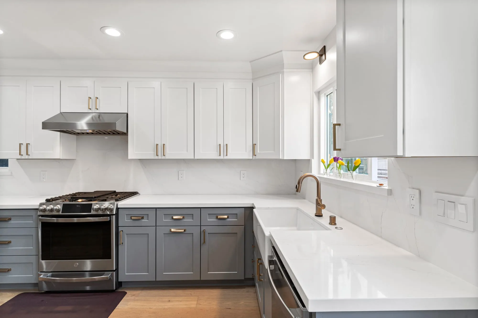 Apron sink under the window with a brass gooseneck tap