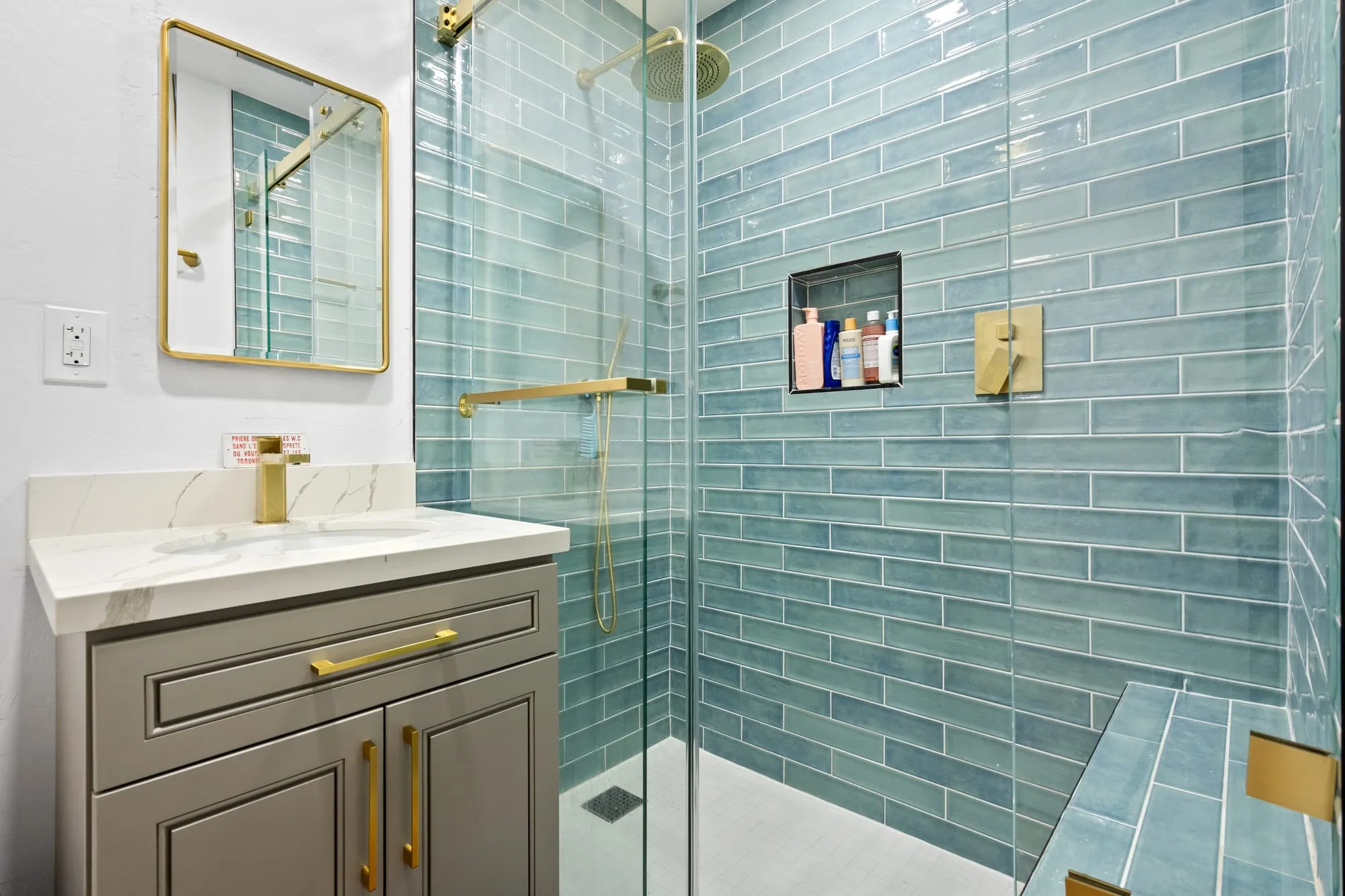 Wide view of the aqua tile shower and its glass panel