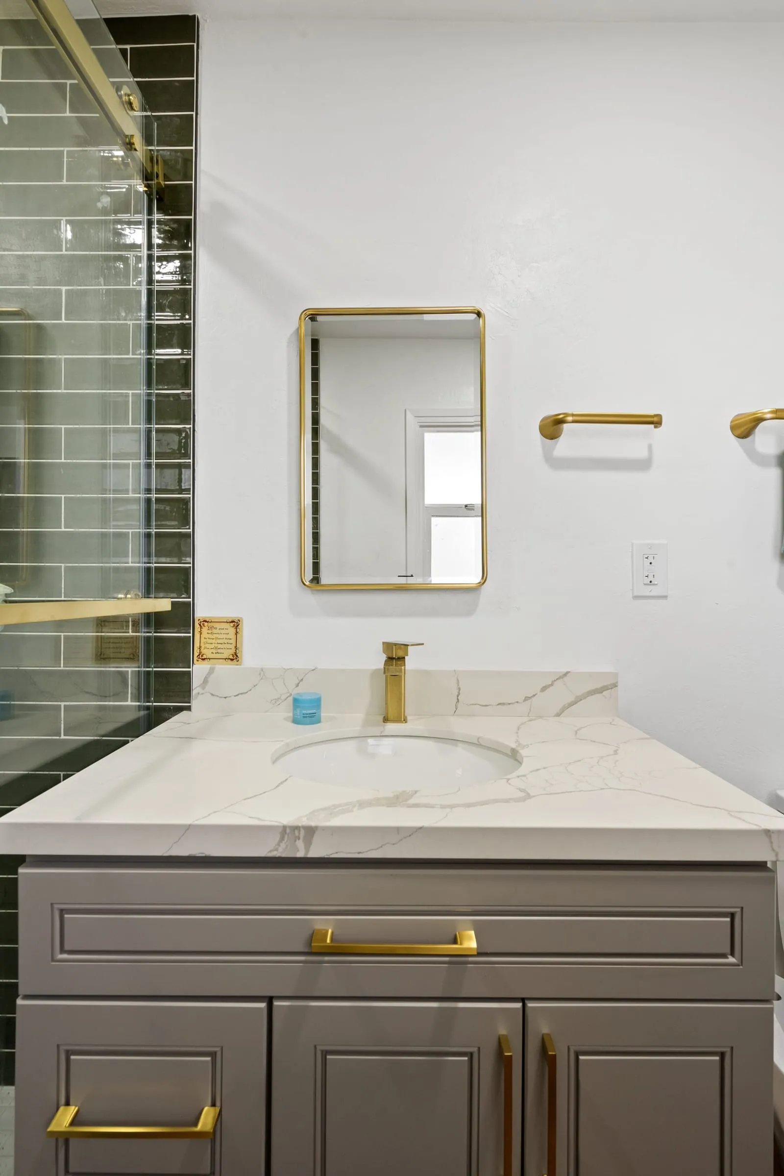 Brass-framed mirror above the quartz counter
