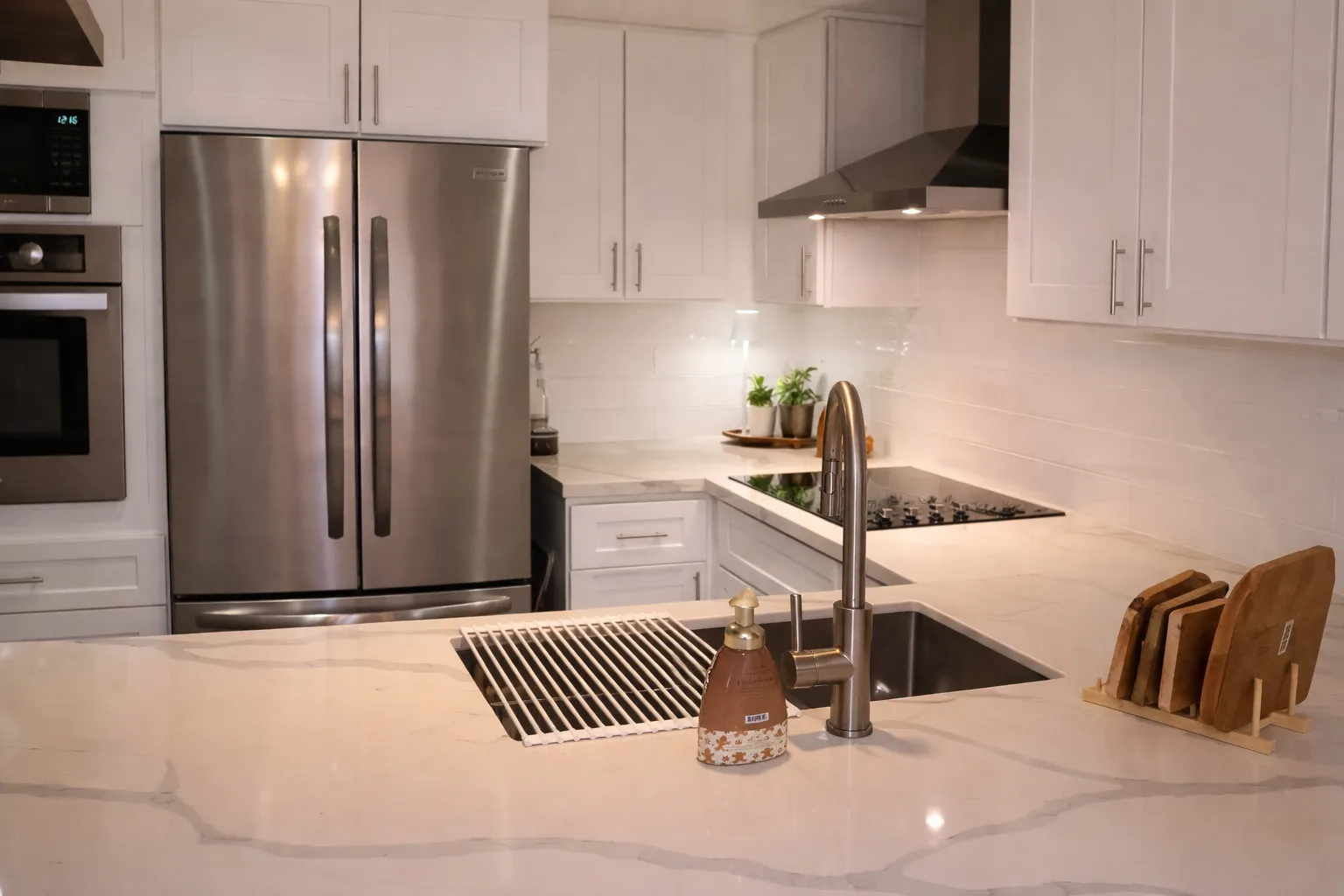 Kitchen counter run in light quartz with soft grey veining, undermount sink and gooseneck tap