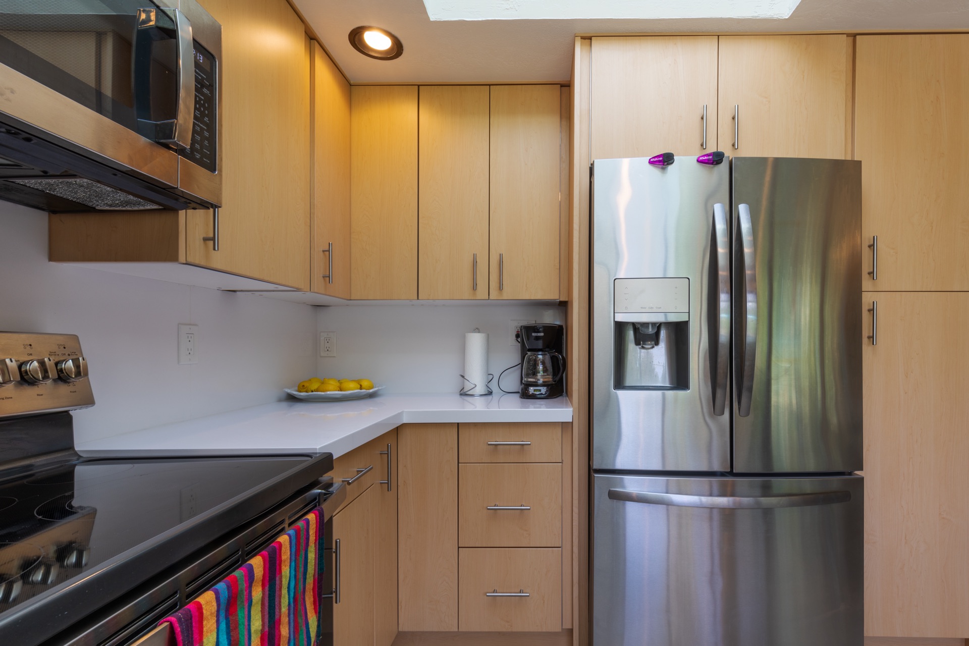 Warm-wood galley kitchen with stainless appliances and quartz counter