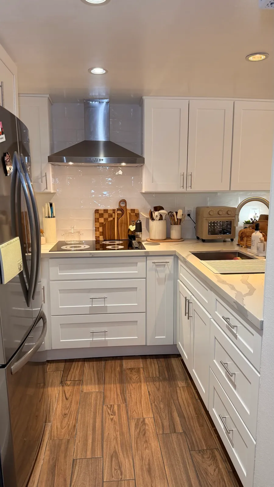U-shape kitchen seen from the doorway, white shaker cabinetry wrapping the room on three sides