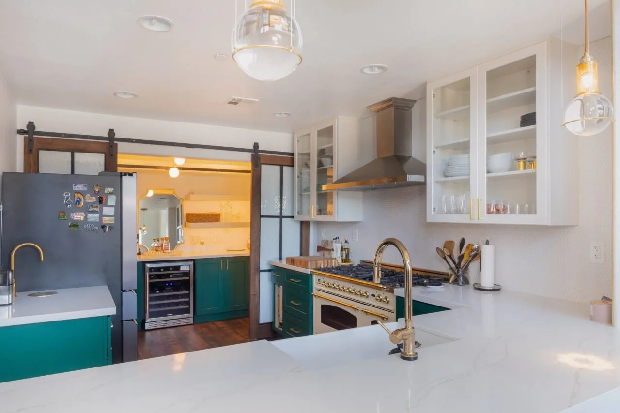 Quartz peninsula with the sliding barn door and pendant lights behind