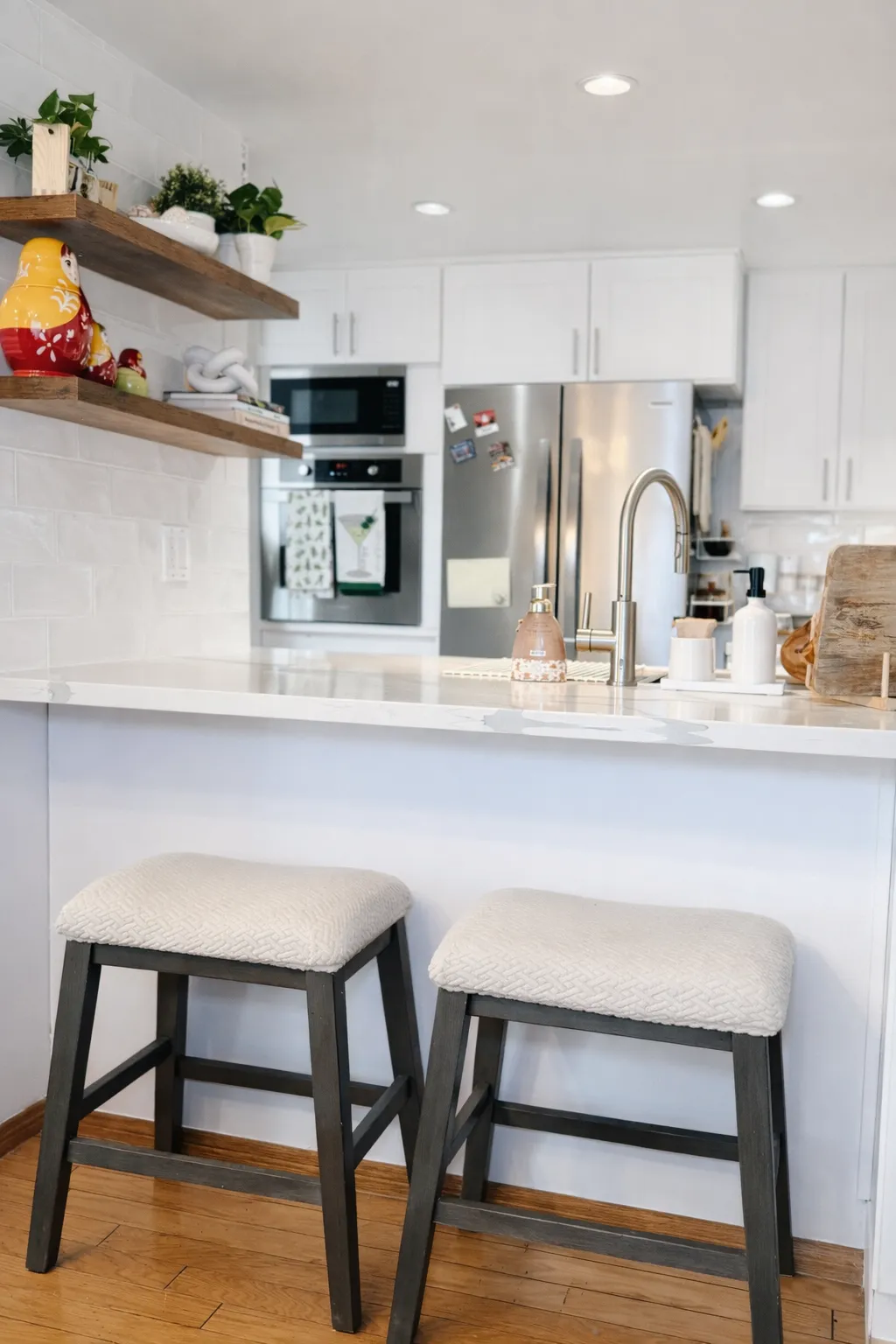 Peninsula seating with two upholstered barstools tucked beneath the quartz counter overhang