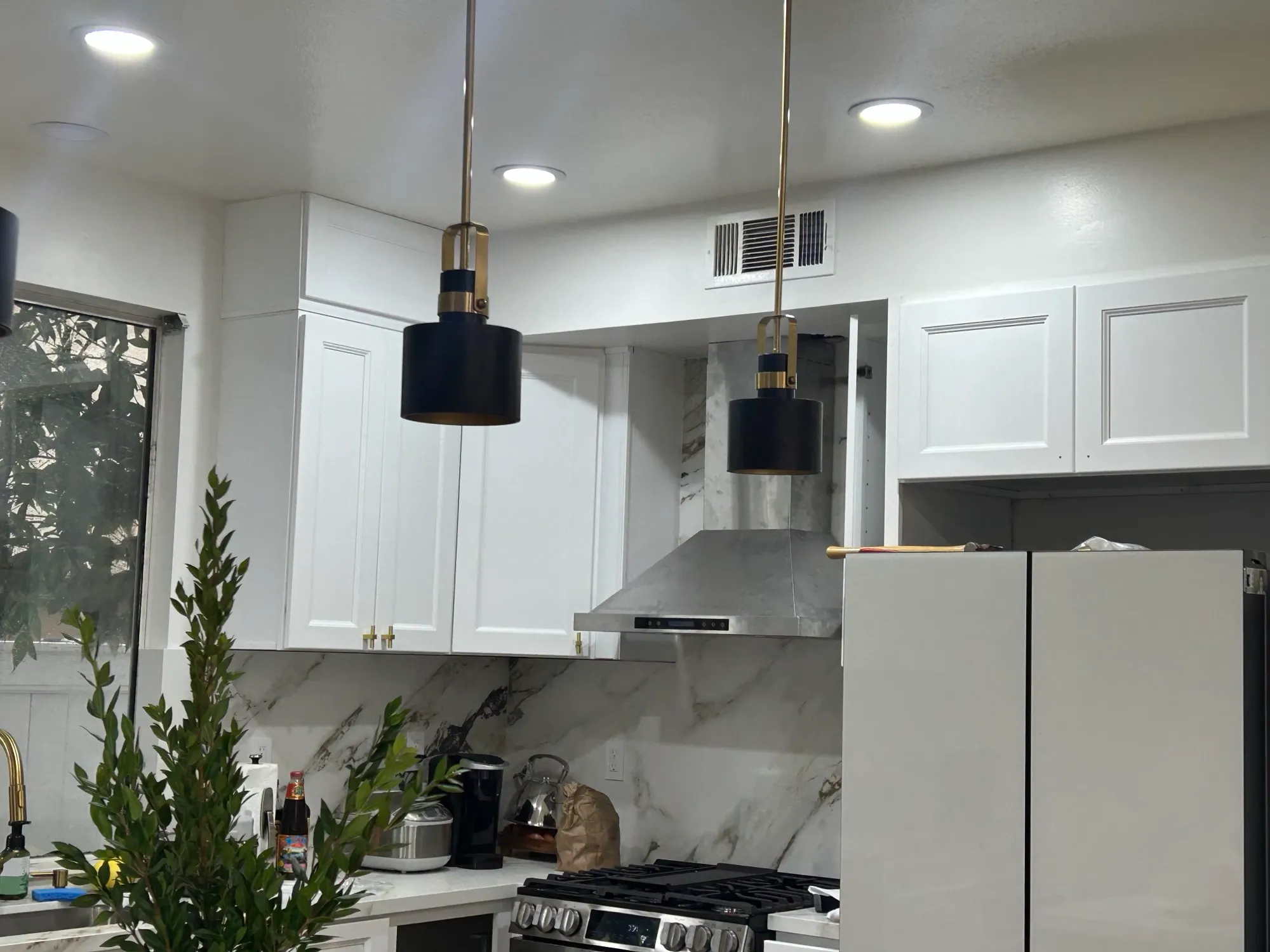 Range wall in the evening, hood and marble-look slab behind