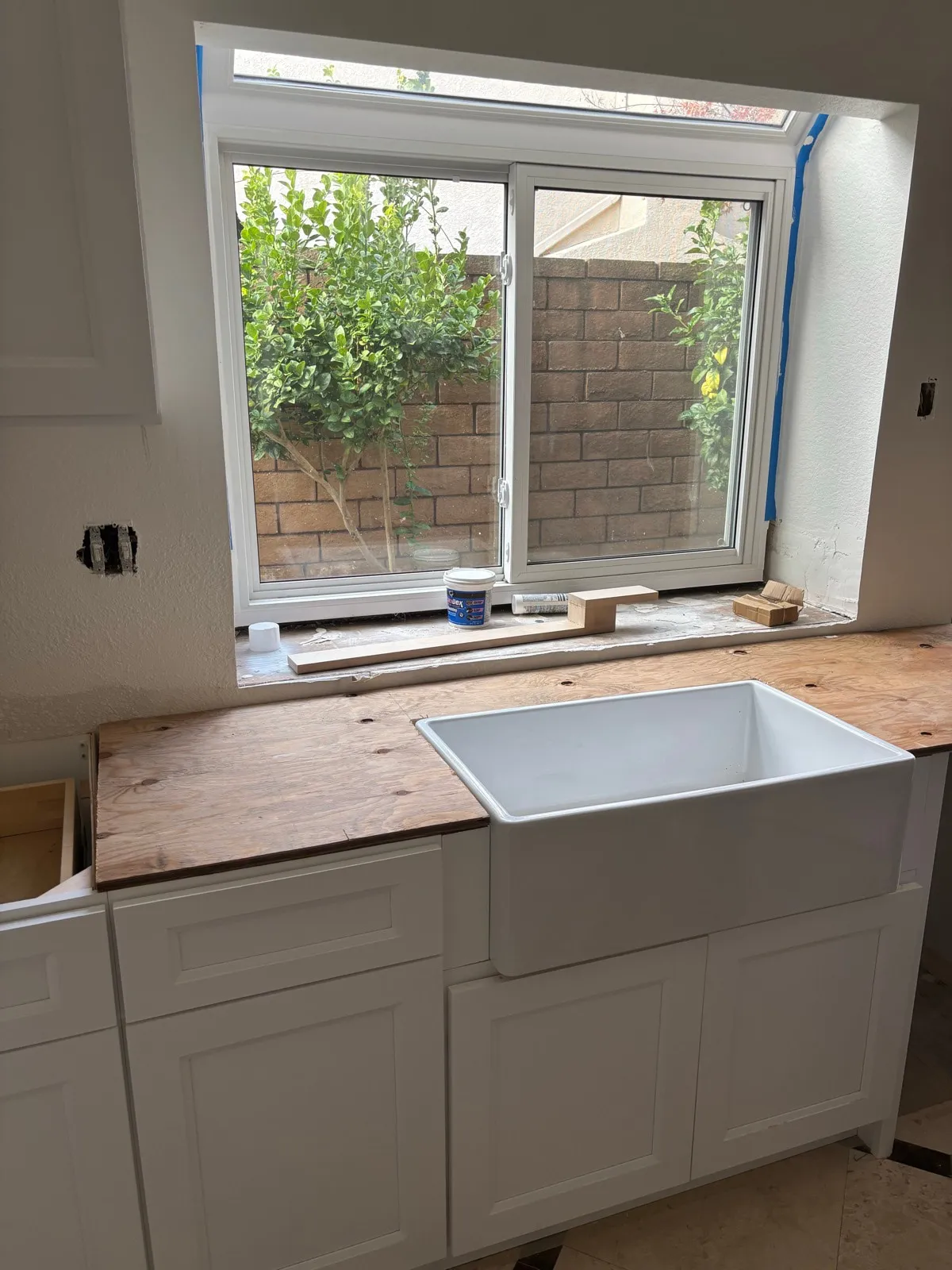 Window frame and plywood sub-frame for the apron sink in place during the build