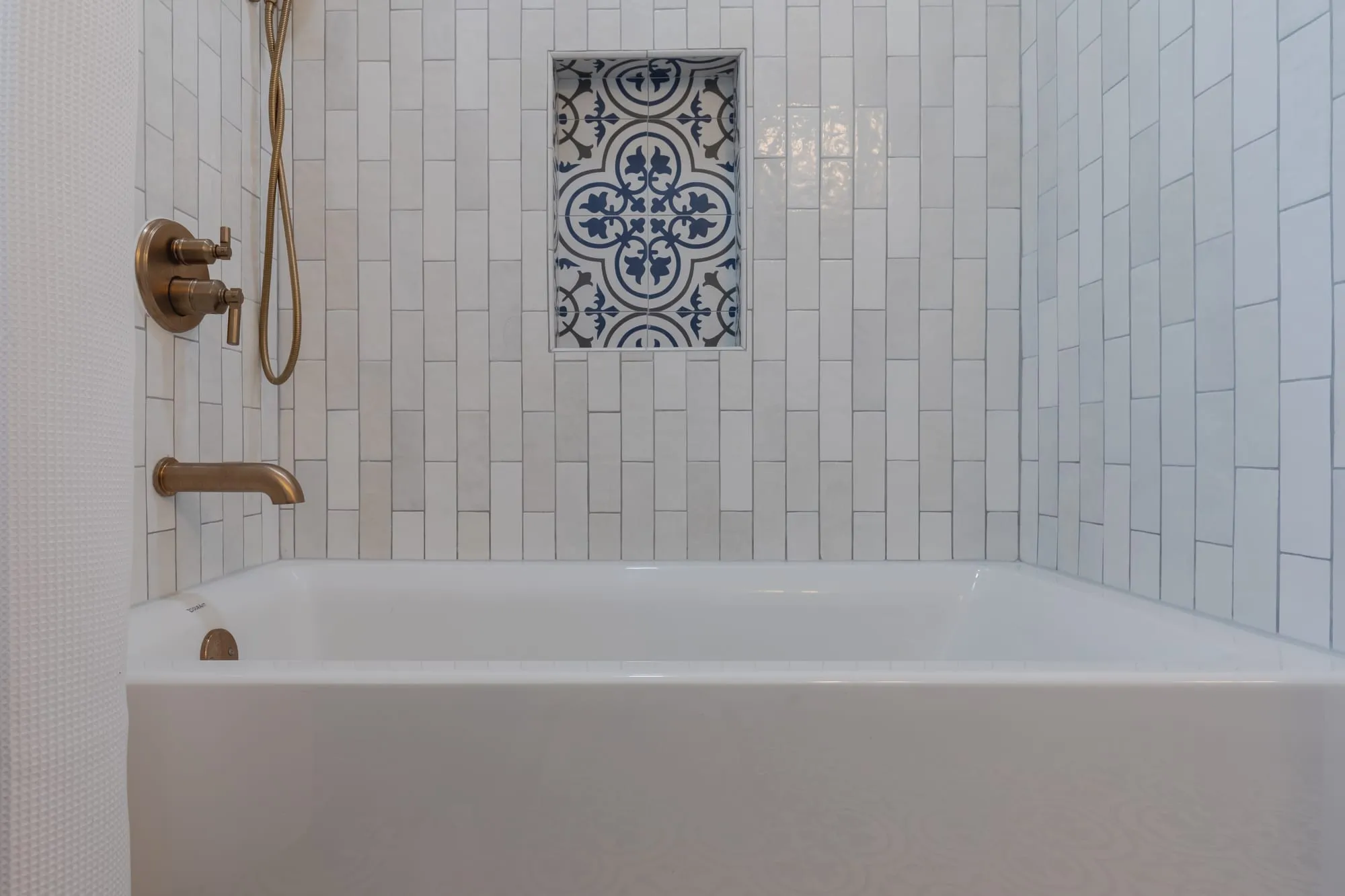 Alcove tub with a patterned tile inset panel above it