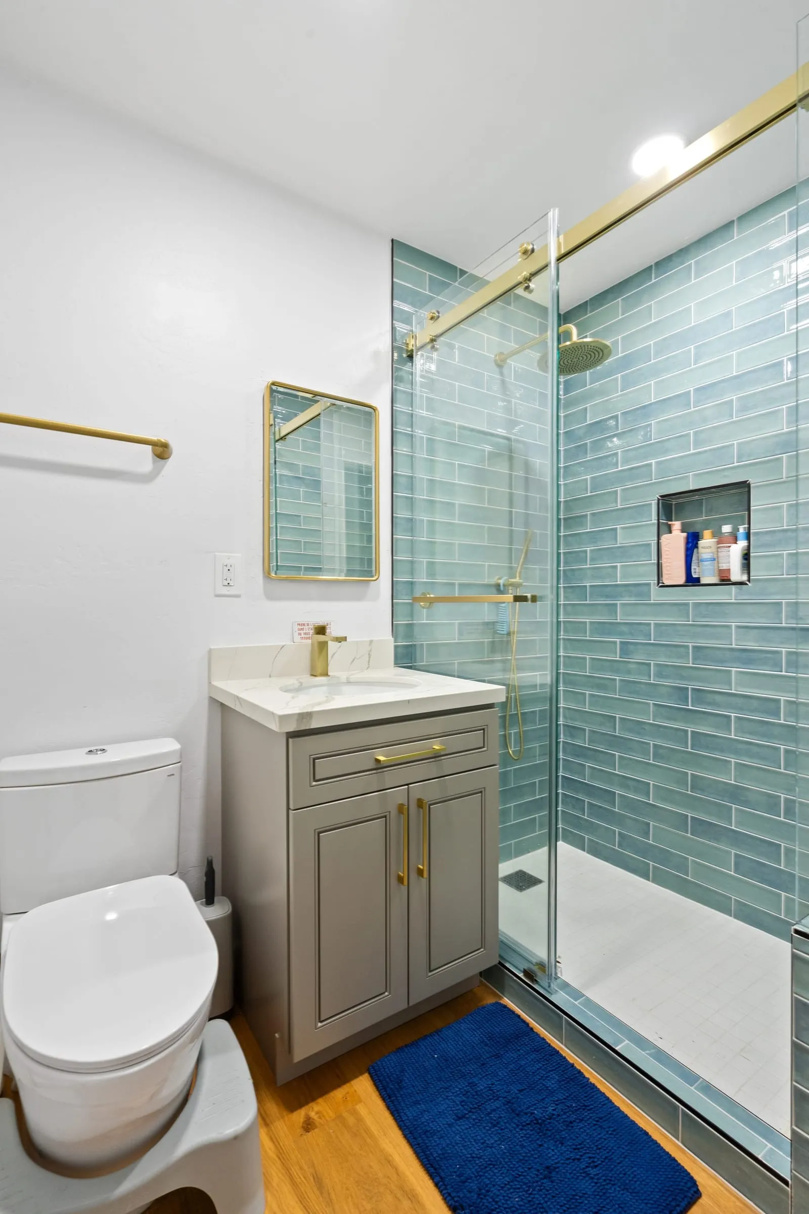 Taupe shaker vanity with a brass-framed mirror above