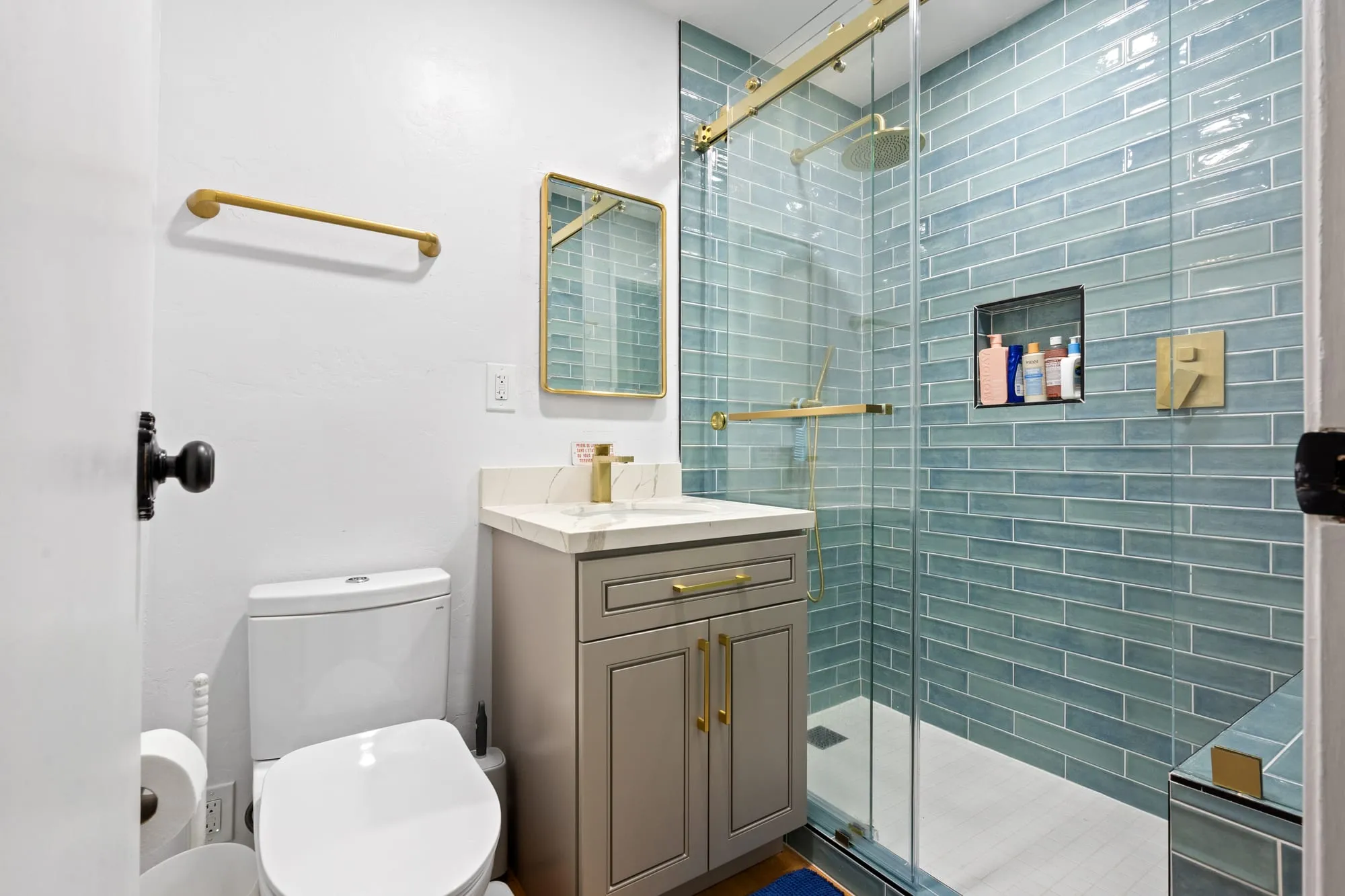 Vanity and shower corner with brass towel bars