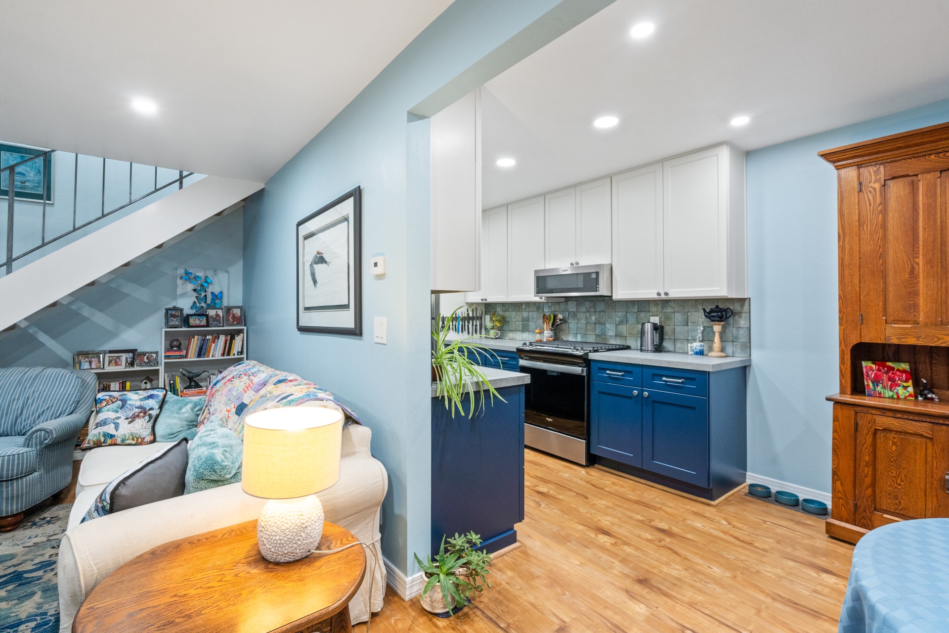Open-plan navy-blue kitchen with adjacent living area and staircase