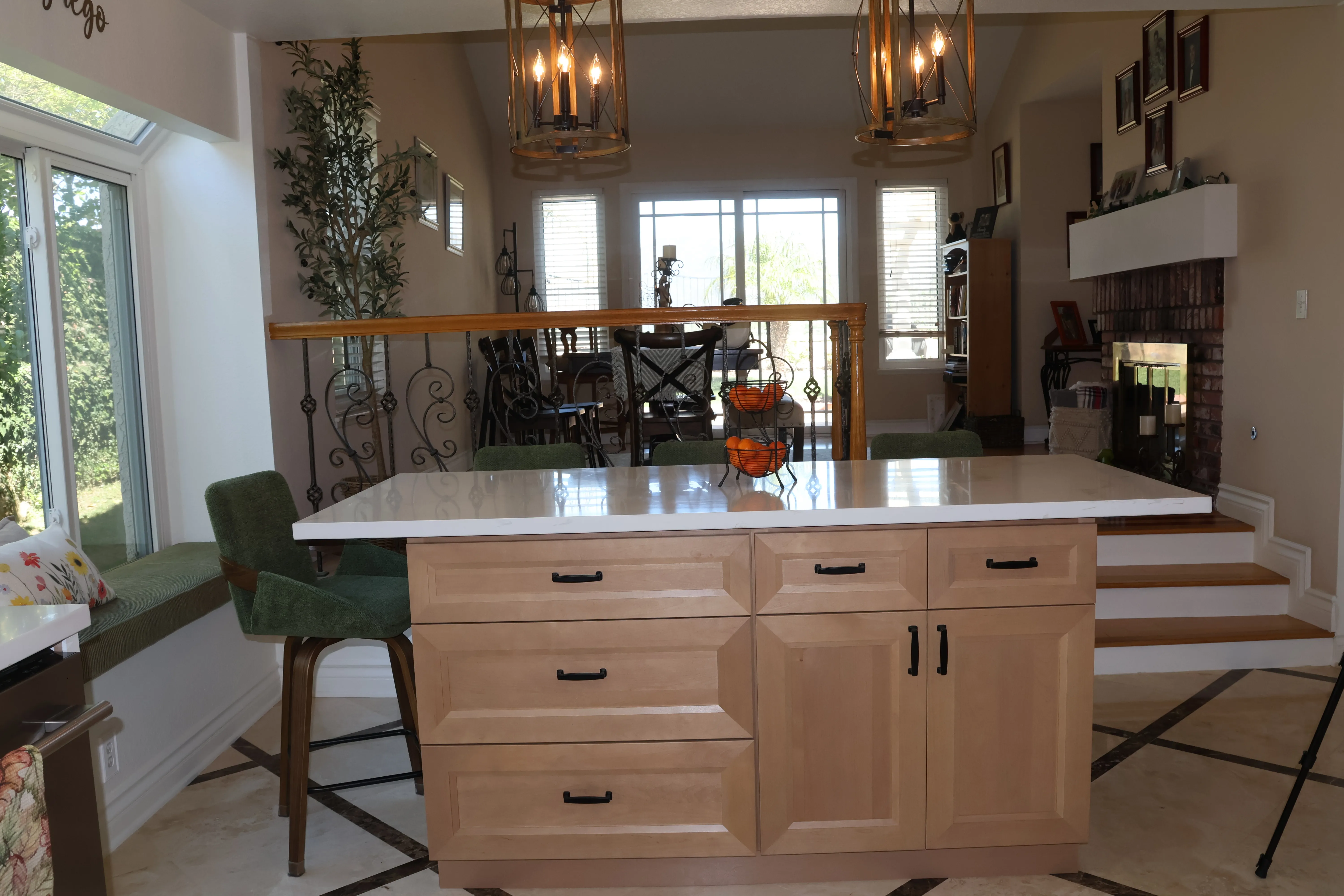 Warm natural-wood island beneath iron lantern pendants, open through to the living room